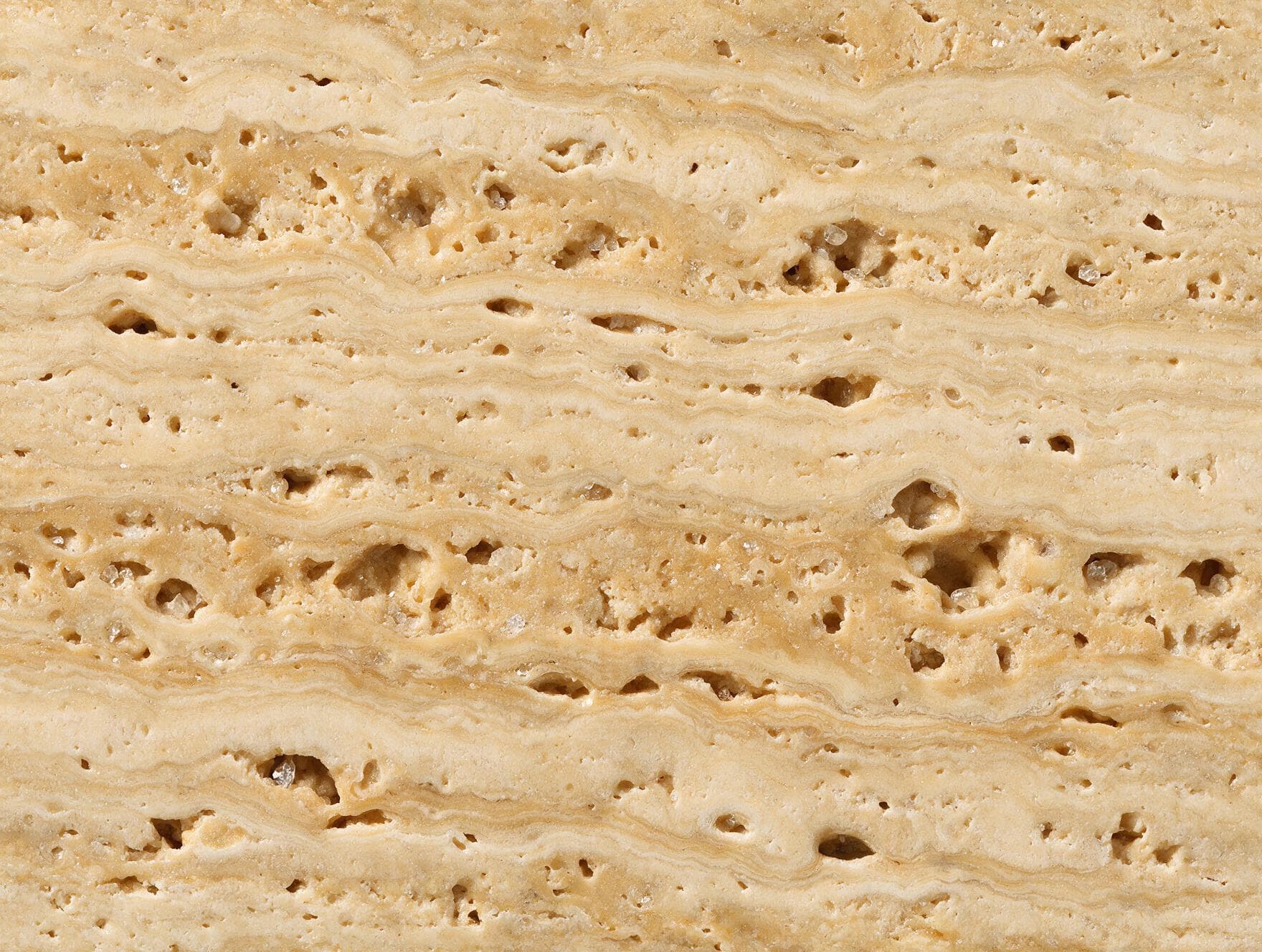 Macro close-up of banded, porous raw travertine stone